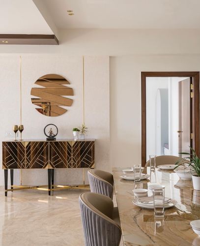 Dining room with marble table, taupe channel chairs, and art deco console with geometric brass inlay