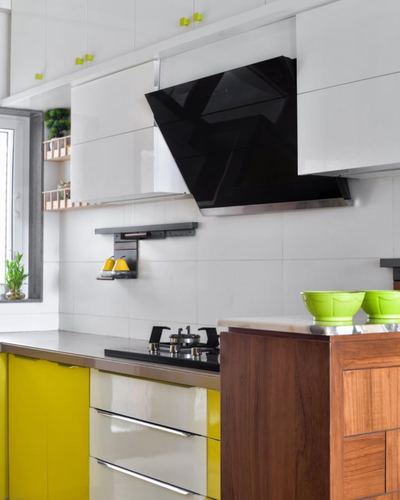 Compact white kitchen with yellow cabinets, black chimney hood, and wood-clad island