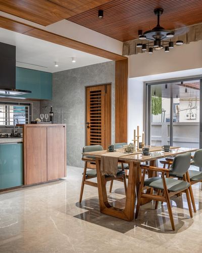 Open dining and kitchen area with wooden ceiling, teal cabinetry, and marble-top table