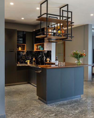 Dark grey kitchen with marble backsplash and suspended black metal bar shelf above island