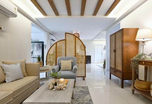 Living room with cane divider, wood beam ceiling, beige sofa and blue armchair