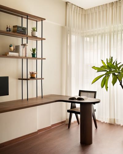 Wooden study nook with shelving, desk, cane chair and sheer curtained window