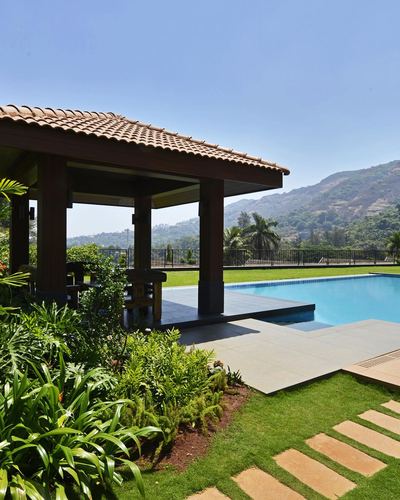 Wooden pavilion with clay tile roof beside pool overlooking Khandala valley