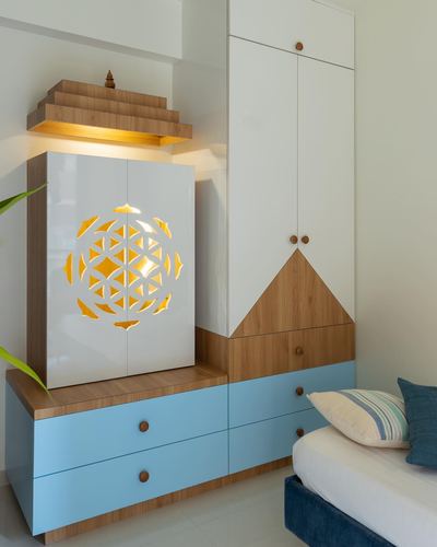 White and blue pooja unit with backlit yantra jaali design beside a wardrobe and bed
