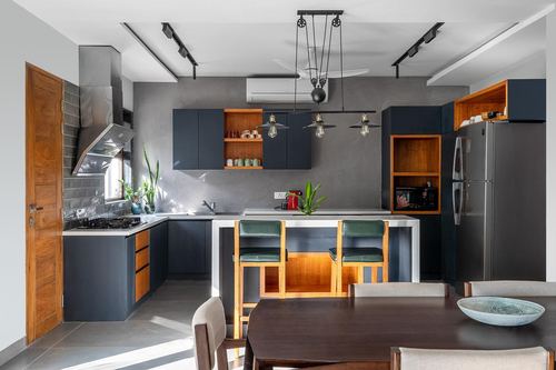 Grey and wood kitchen with island, green bar stools, and pulley pendant light in Chennai home