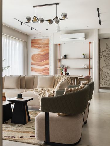 Living room with beige sectional, olive quilted armchair, and abstract terracotta painting under a globe pendant light.
