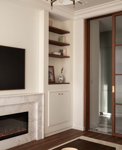 Living room corner with marble fireplace, walnut floating shelves, and a reeded glass sliding door beyond