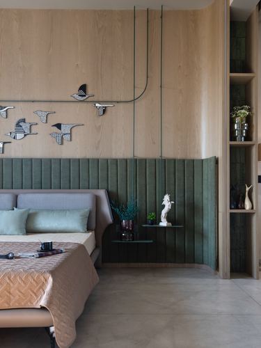 Bedroom with wood-panelled wall, green channel-tufted headboard, hanging shelf, and bird wall art