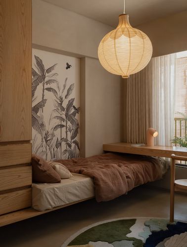 Warm-toned bedroom with wooden bed platform, large woven pendant lamp, and botanical mural on wall