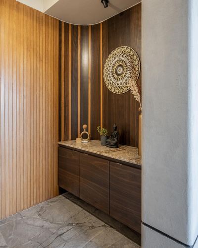 Foyer with fluted wood wall, marble-look console, buddha statue and jute wall art