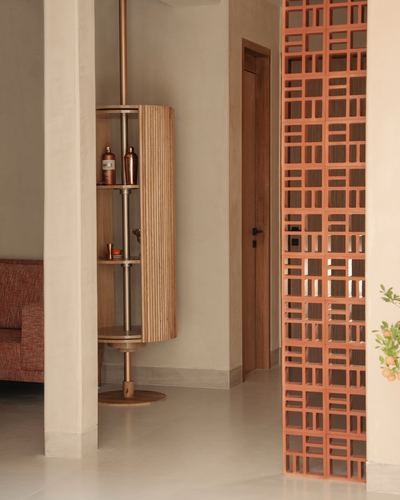 Passage with terracotta jali screen and rotating wooden shelf on a brass pole