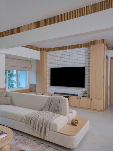Minimalist living room with white brick tv wall, fluted wood panelling, and beige sectional sofa
