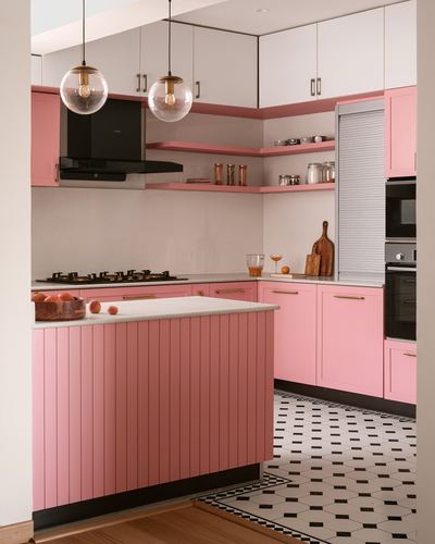 Pink kitchen with fluted island, black chimney hood, and black-and-white patterned floor tiles