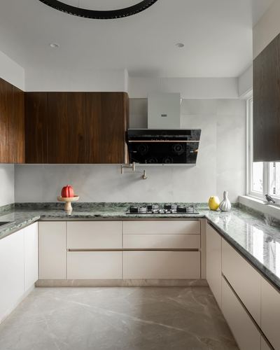 L-shaped kitchen with green stone counters, walnut upper cabinets, and pot filler over cooktop