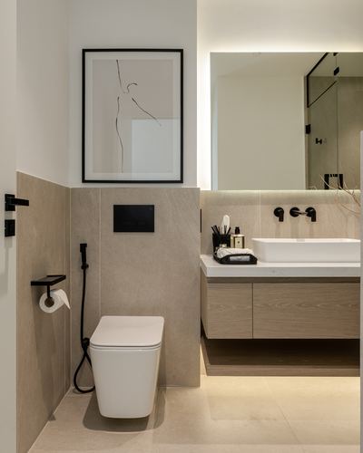 Neutral-toned bathroom with wall-hung toilet, stone tile walls, and floating wood vanity with vessel sink