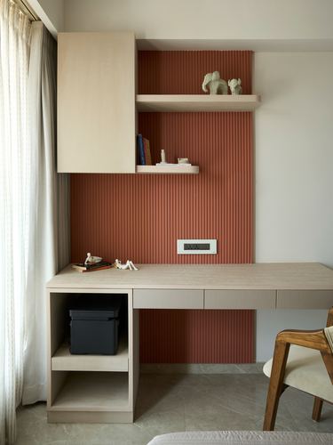 Study nook with fluted terracotta wall panel, floating shelves, wooden desk and cane chair