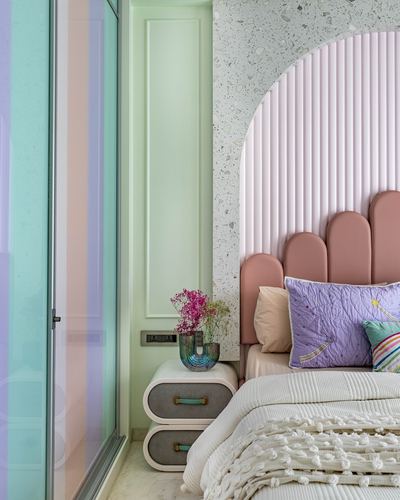 Pastel bedroom with scalloped pink headboard in fluted arch niche and mint wardrobe