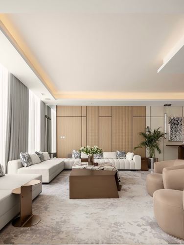 Living room with cream L-shaped sofa, fluted wood wall, and stone-topped coffee table under warm cove lighting