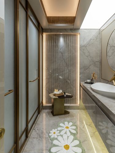 Marble bathroom with backlit fluted panel, vessel sink, and daisy-print bath mat on floor