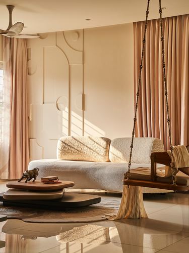 Boucle jhula swing beside cream sofa against sculpted wall in warm morning light