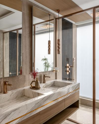 Double marble vanity with brass pendant lights and fluted wood ceiling in a bathroom