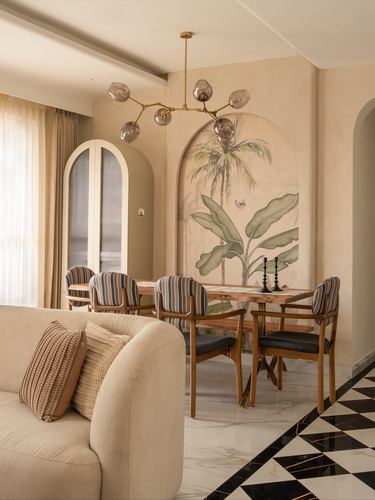 Dining nook with striped chairs beneath a botanical mural arch and checkerboard marble floor