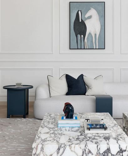 White living room with paneled wall, navy accents, marble coffee table, and horse painting