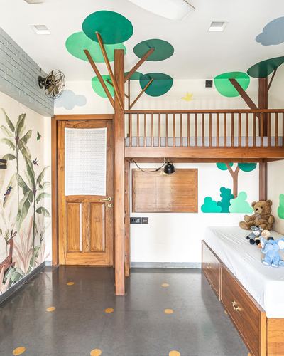 Children's bedroom with tree-shaped wooden loft bed and painted forest mural on walls and ceiling