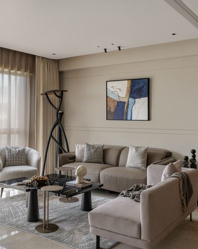 Beige living room with leather sofas, sculptural lamp, nesting tables, and abstract art
