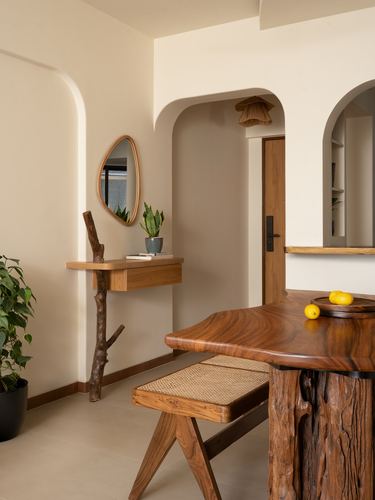 Foyer with arched niches, wooden console, mirror and live-edge wood dining table with cane bench