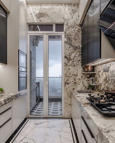 Narrow marble-clad galley kitchen with gas hob, city view through glass balcony doors