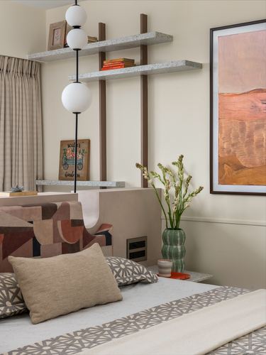 Bedroom nook with terrazzo shelves, globe pendant, geometric headboard and framed art