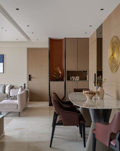 Beige dining area with oval marble table, leather chairs, wood panelling and gold spiral wall clock