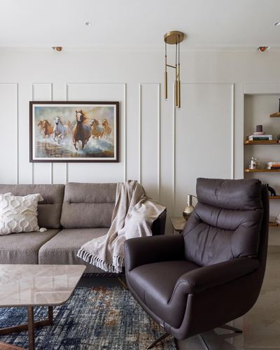 Living room with grey sofa, brown leather recliner, horse painting, marble coffee table on navy rug