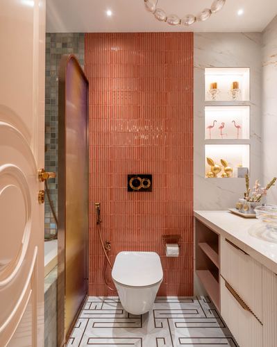 Bathroom with coral fluted tile wall, wall-hung toilet, marble niches with flamingo decor, and marble vanity