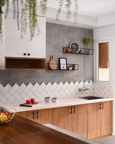Modern kitchen with white cabinets, wood base units and herringbone tile backsplash