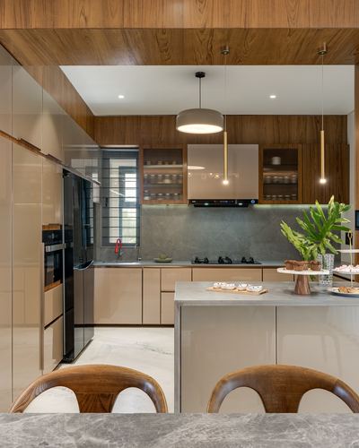 Modern kitchen with wood ceiling, beige cabinetry, stone island and pendant lights