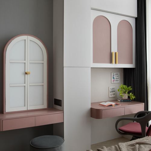Pink and grey study nook with arched cabinet doors, arched mirror, and floating desks