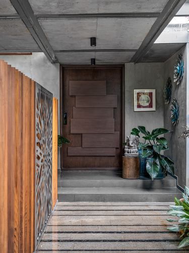 Entry walkway with slatted wood wall, CNC panel, and paneled wooden pivot door