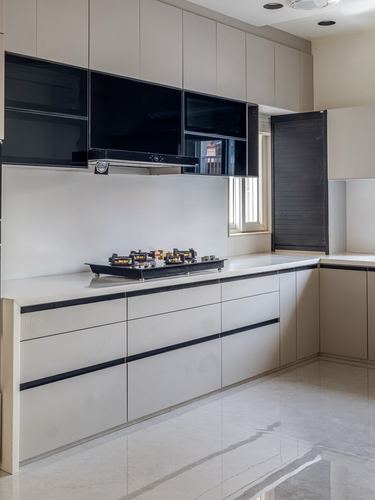 Modern white kitchen with glossy black upper cabinets and a built-in gas hob on white countertop