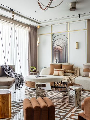 Living room with curved beige sofa, swing chair, glass table on patterned marble floor