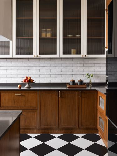 Kitchen with fluted glass cabinets, subway tile, wood lower units, checkerboard floor