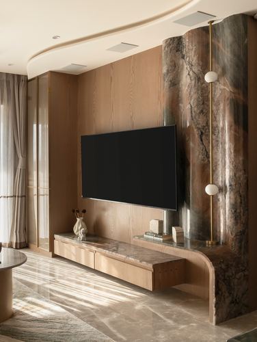 Living room with wood-panelled TV wall meeting a curved veined stone feature and floating console