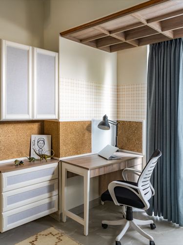 Study nook with cork panel walls, wooden desk, task chair, and coffered wood ceiling niche