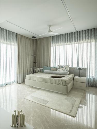 Minimalist bedroom with floating bed, sheer floor-to-ceiling curtains, and marble flooring