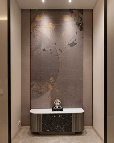 Foyer niche with leaf-patterned mural wall above a curved marble-top console holding a small Ganesha idol