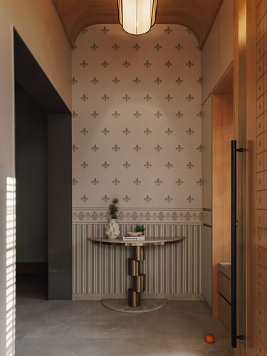 Foyer with fleur-de-lis wallpaper, curved wood ceiling, and brass-legged console table
