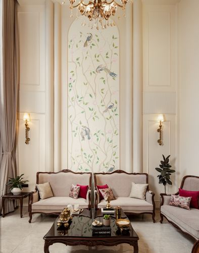 Neo-classical living room with carved sofas facing a hand-painted bird and floral mural niche