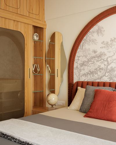 Bedroom corner with terracotta arched headboard, tree mural, wood wardrobe and wavy mirror niche